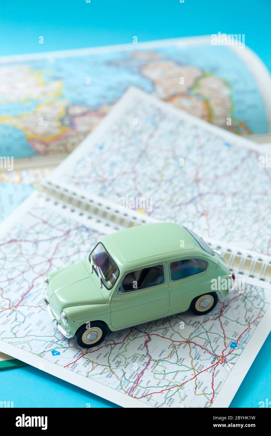 Auto classica europea in miniatura che guida attraverso una mappa stradale. Spazio per il testo. Concetto di viaggio e turismo in auto. Foto Stock