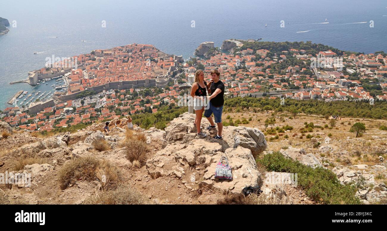 I turisti scattano foto da una posizione sopra la città vecchia di Dubrovnik in Croazia Foto Stock