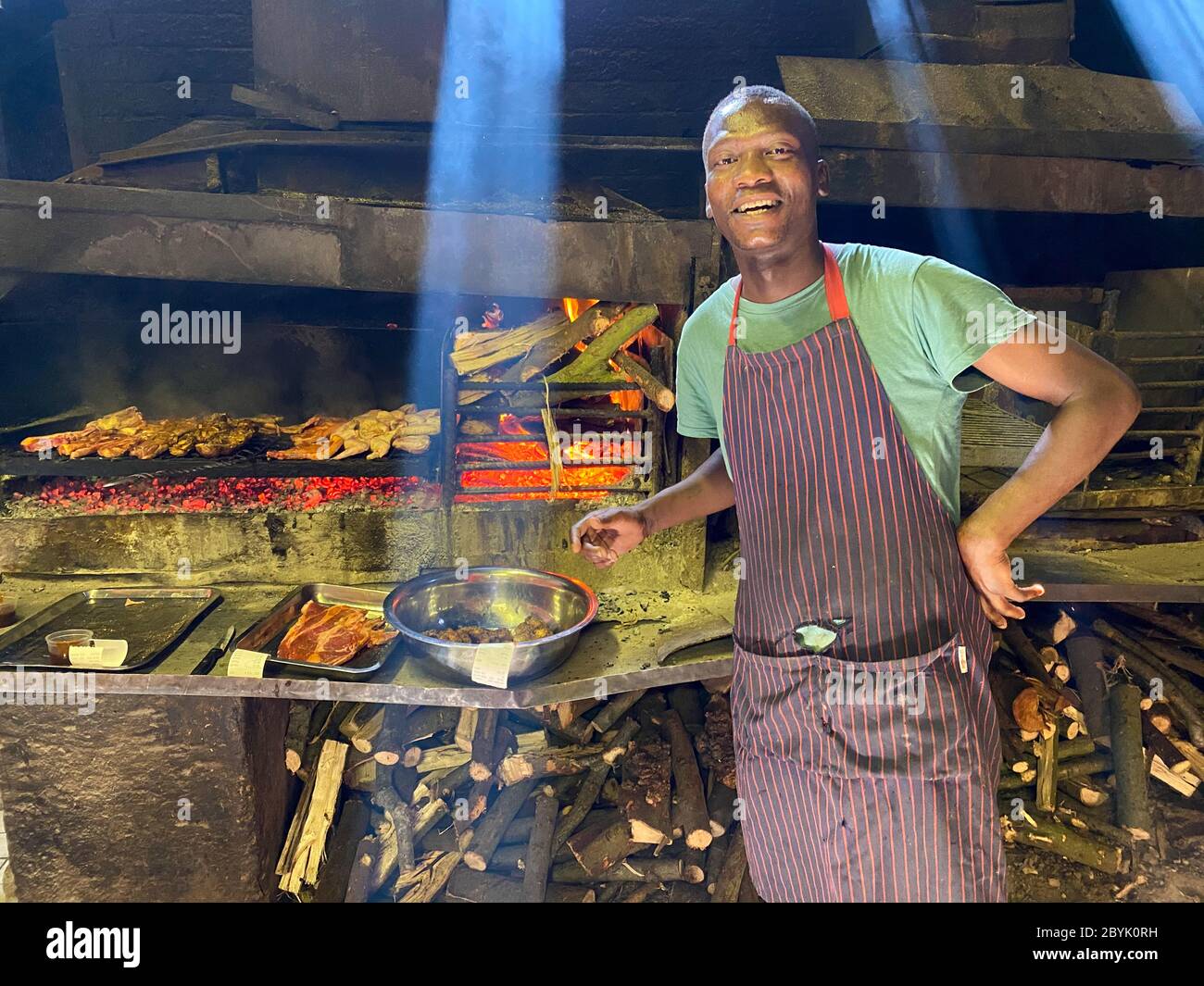 Uno degli chef esperti del Mzoli's Meat Market in attesa di cibo per finire la cucina, Città del Capo, Sud Africa Foto Stock
