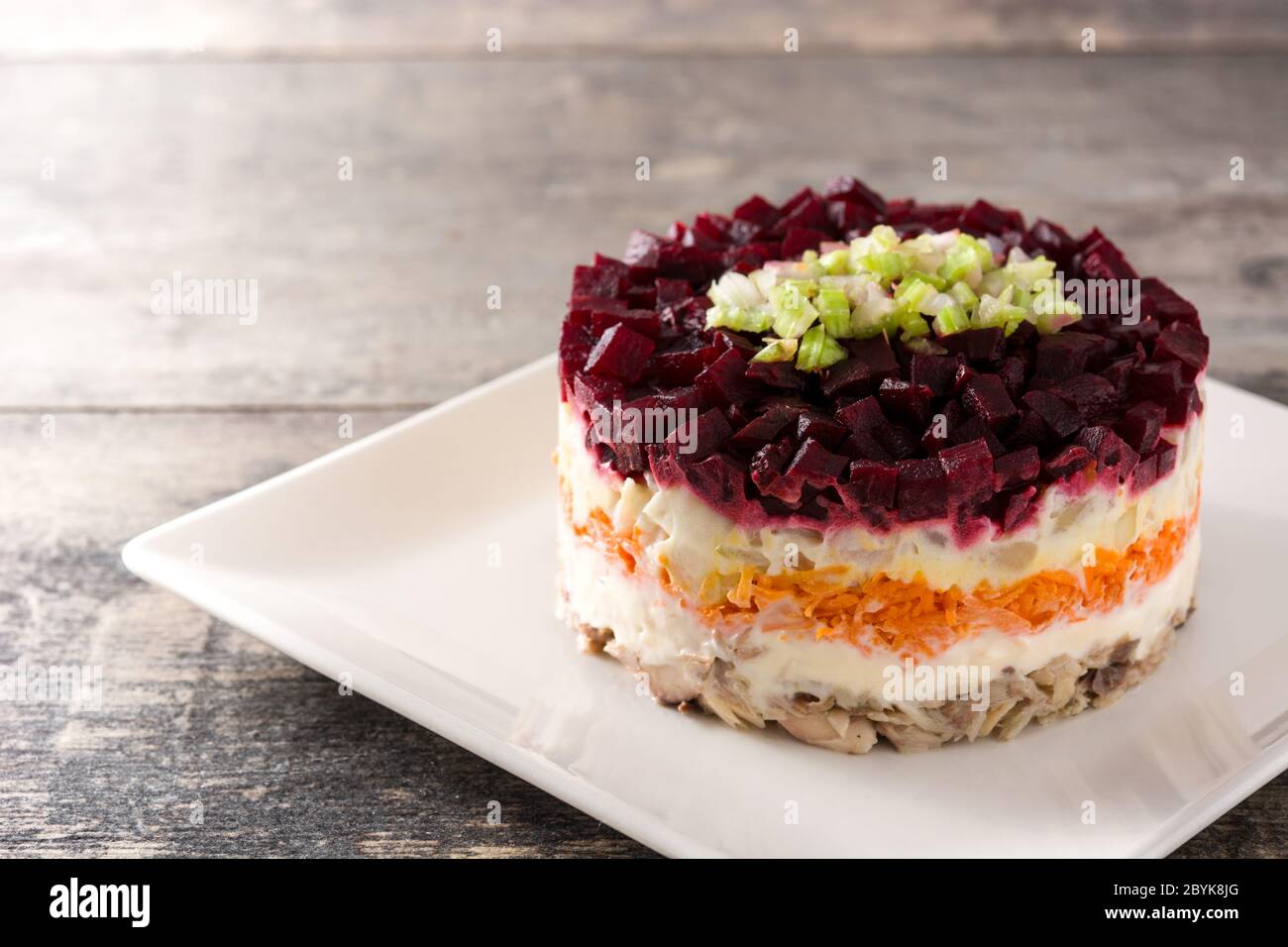 Insalata tradizionale russa di aringhe con barbabietole e carote su tavolo di legno Foto Stock