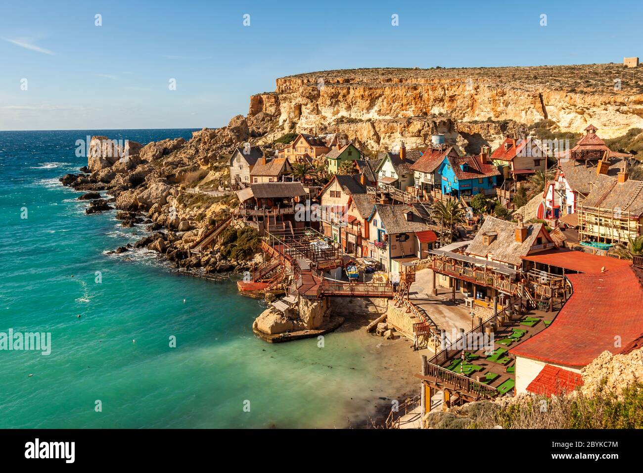 Il colorato villaggio cinematografico noto come Popeye Village si trova in una baia rocciosa vicino a Mellieħa, Malta. È stato costruito nel 1980 come location per il musical in live-action "Popeye", con Robin Williams nei panni del marinaio amante degli spinaci. Foto Stock