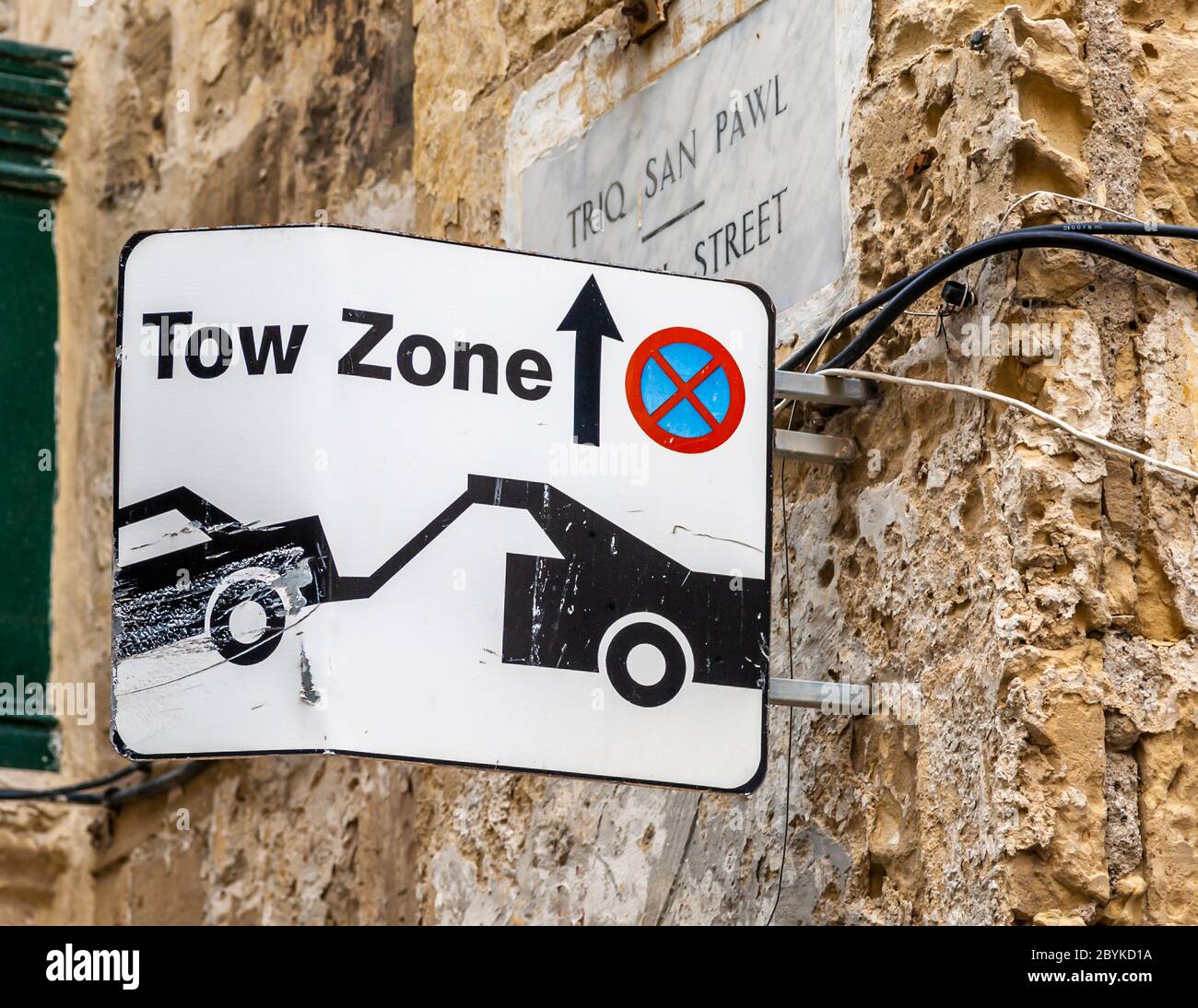 Un cartello avverte della zona di rimorchio su Triq San Pawl (via San Paolo) a Saint Paul's Bay, Malta. Foto Stock