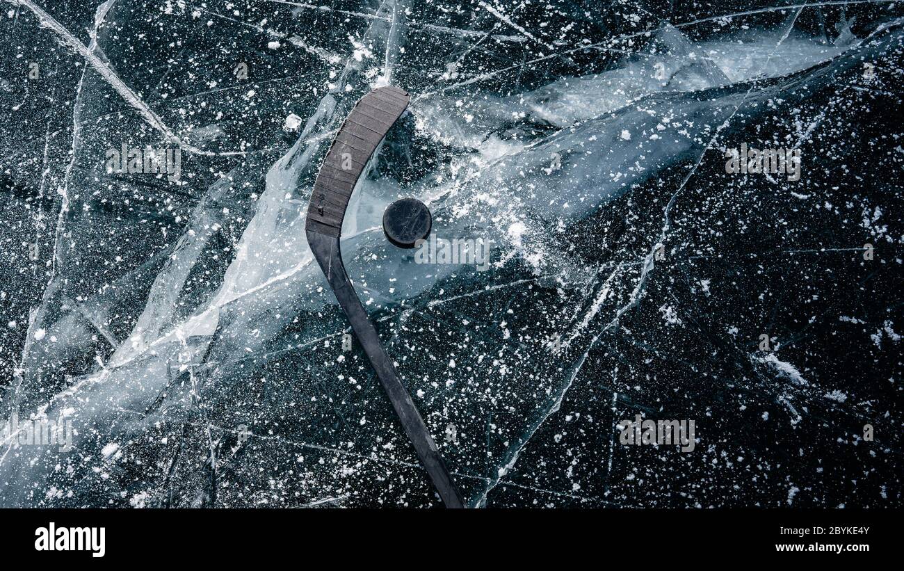Dettagli primo piano su disco di hockey su uno stagno congelato. Pattinaggio su ghiaccio in natura al tramonto in inverno. Viaggi e sport Foto Stock