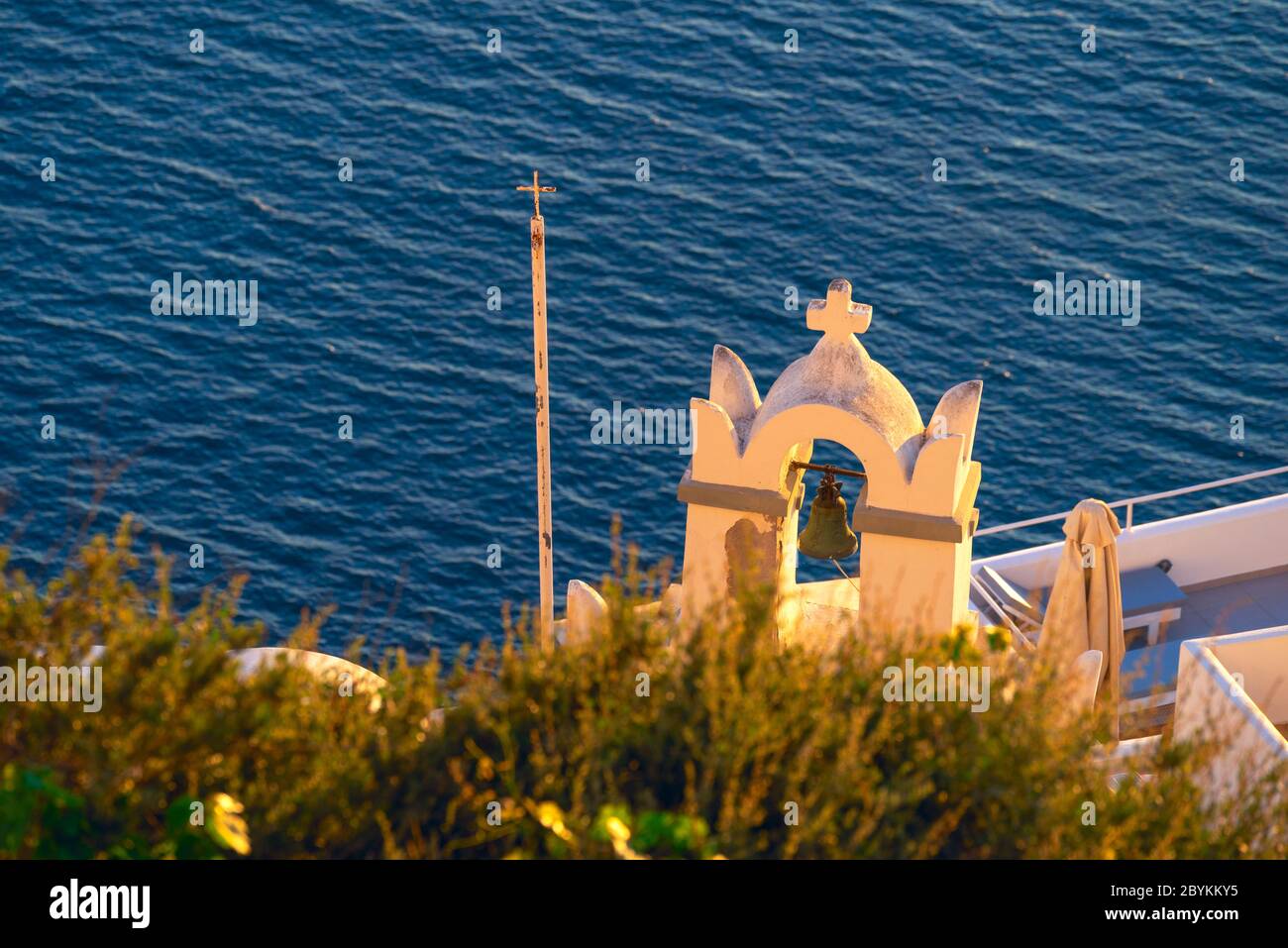 Vecchio campanile al tramonto che si affaccia sul Mar Egeo sull'isola greca di Santorini Foto Stock
