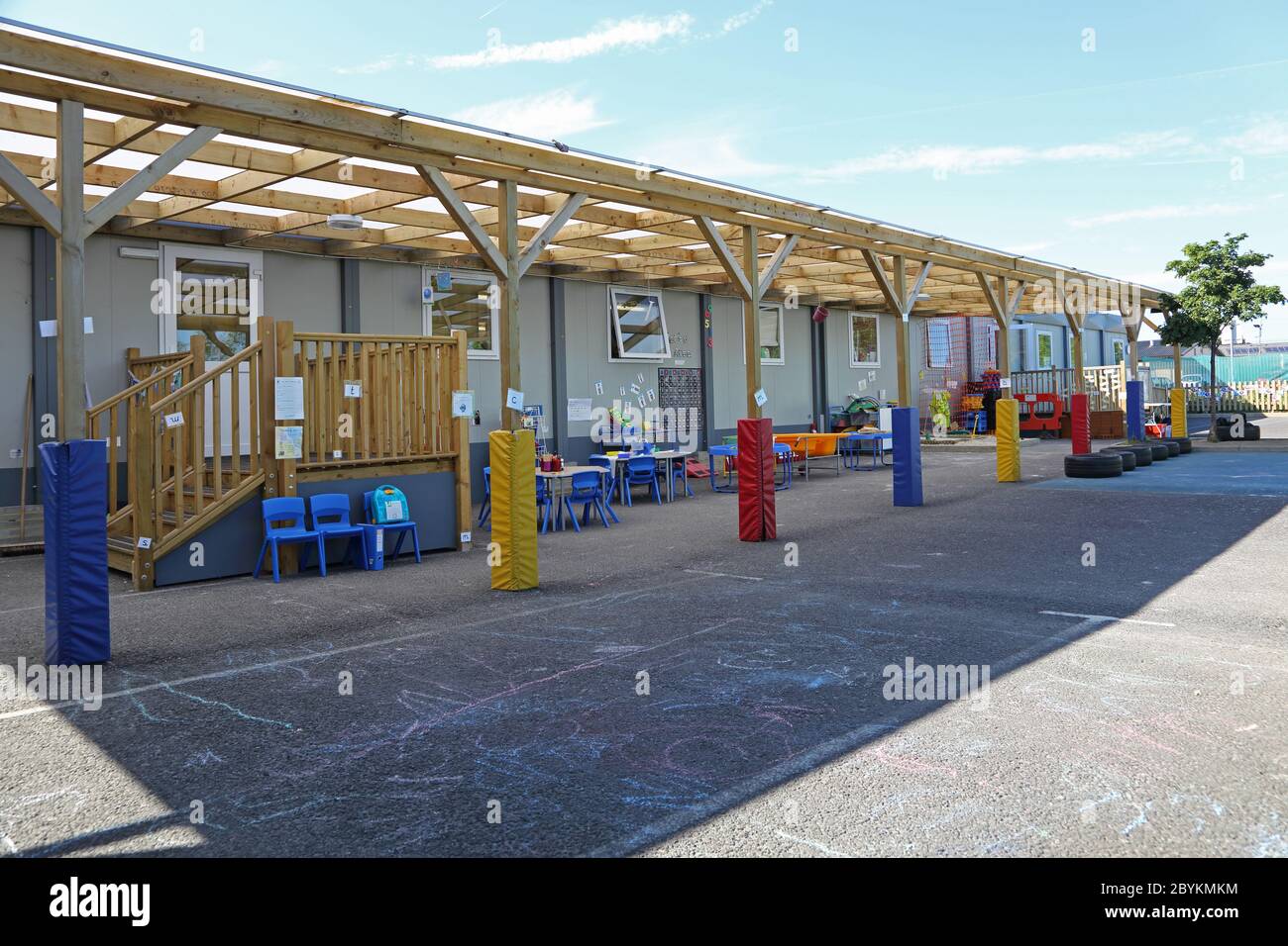 Aule temporanee erette nel parco giochi di una scuola junior londinese, Regno Unito. Costruito in unità modulari e dotato di un'area giochi all'aperto coperta. Foto Stock
