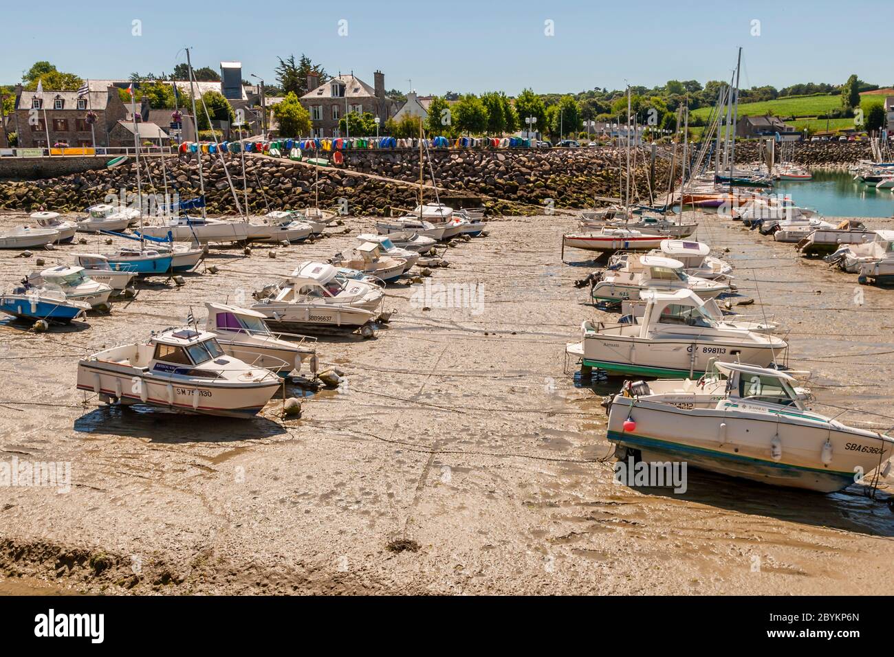 Le barche si trovano in piedi sulle loro chiglia in un bacino asciutto. Porto di Plévenon a bassa marea, Francia Foto Stock