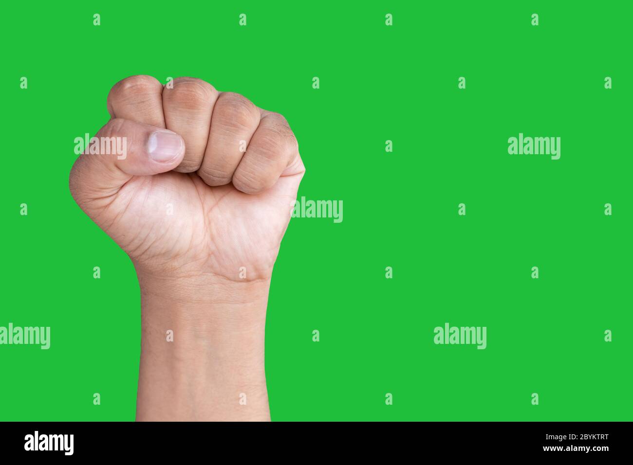 Mano di un uomo asiatico forma pugno isolato su uno sfondo verde schermo. Foto Stock