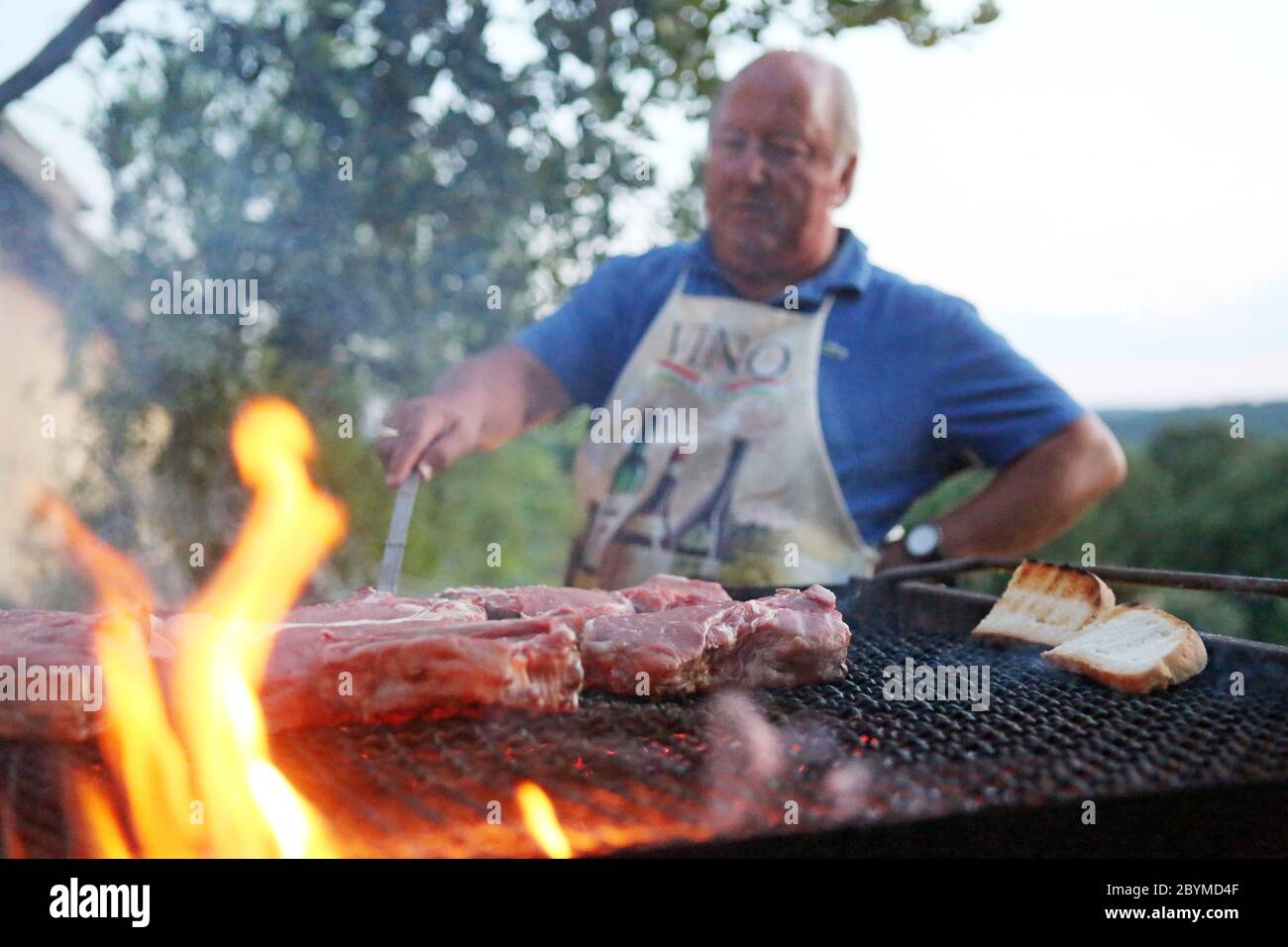 01.08.2016, Pomantello, Viterbo, Italia - l'uomo prepara la carne alla griglia. 00S160801D003CAROEX.JPG [RELEASE DEL MODELLO: NO, RELEASE DELLA PROPRIETÀ: NO (c) immagine caros Foto Stock