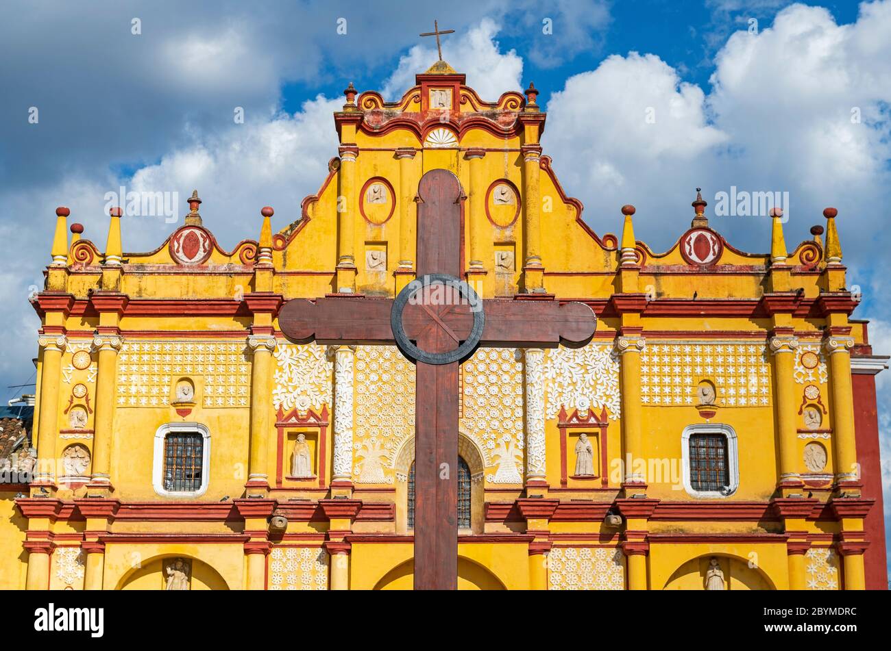 Facciata della Cattedrale di San Cristobal de las Casas con una croce di legno di fronte, Chiapas, Messico. Focus su Cross, edificio poco affilato. Foto Stock