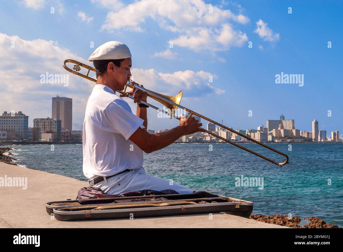 L'uomo gioca il trombone sulla parete di El Malecon, Havana, Cuba Foto Stock