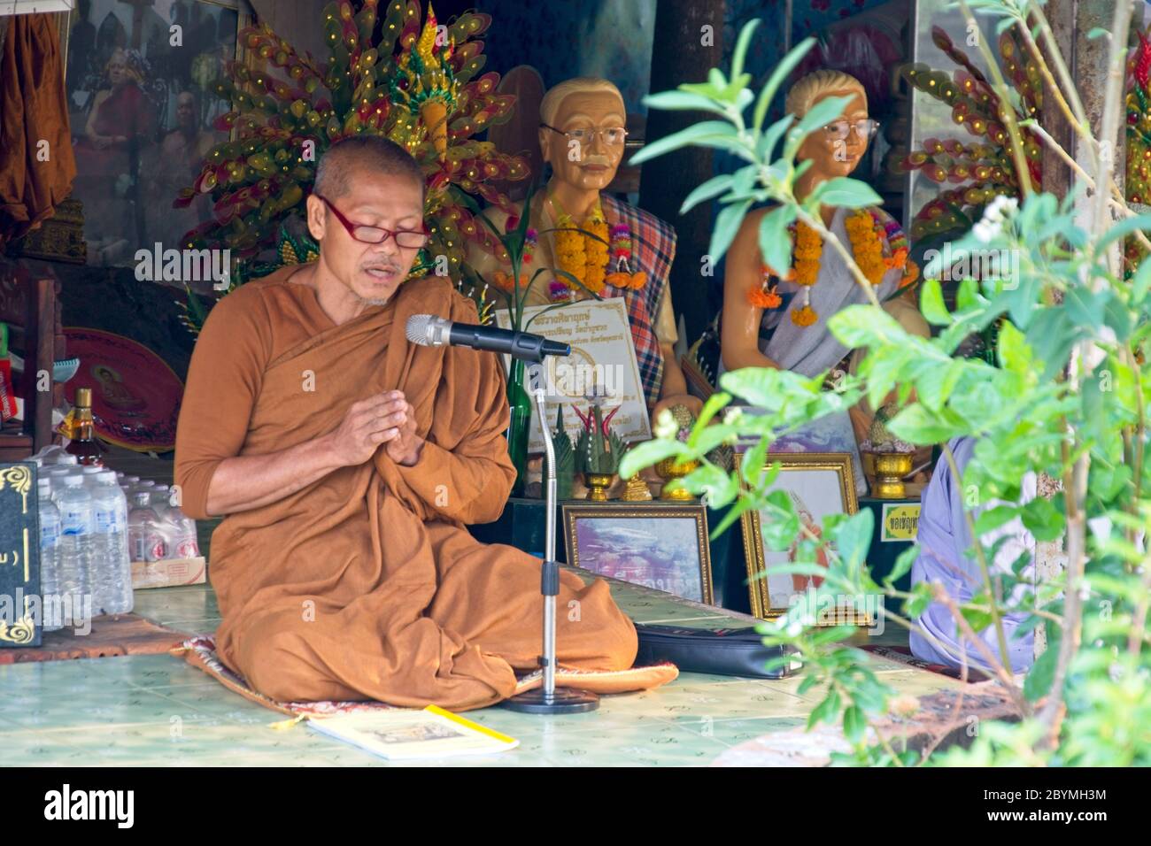 Bhuddisto monk che canta a un microfono. Foto Stock