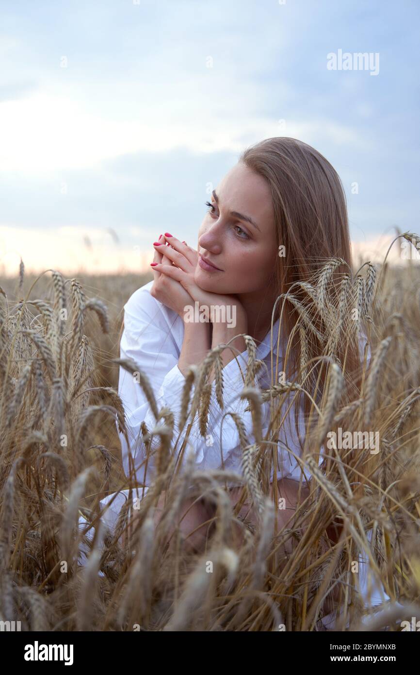 Portait di una donna all'aperto, fuoco selettivo. Donna su campo di grano. Foto Stock
