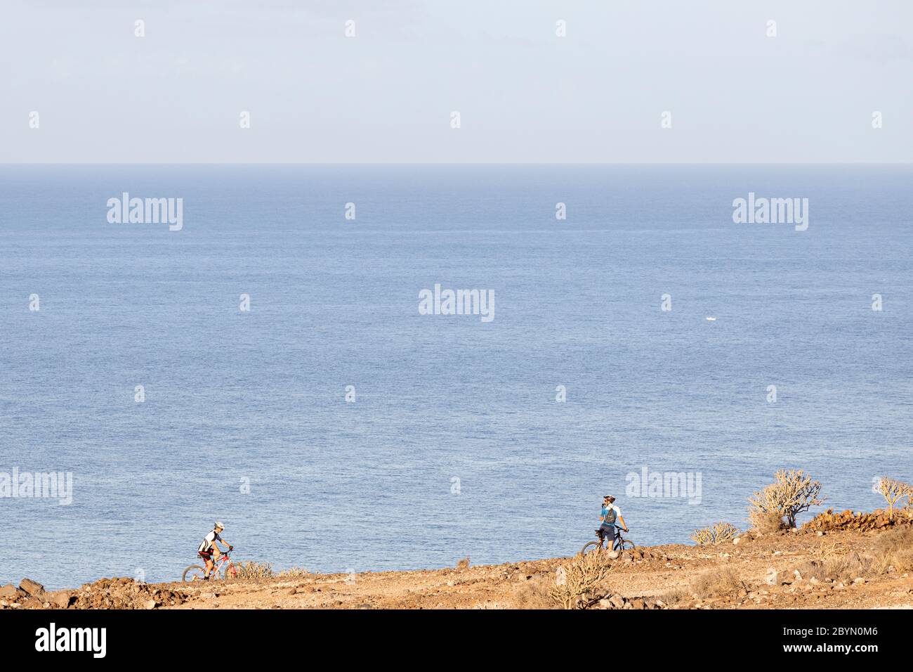 Ciclisti sulle scogliere sopra il mare a la Caleta, Costa Adeje, Tenerife, Isole Canarie, Spagna Foto Stock