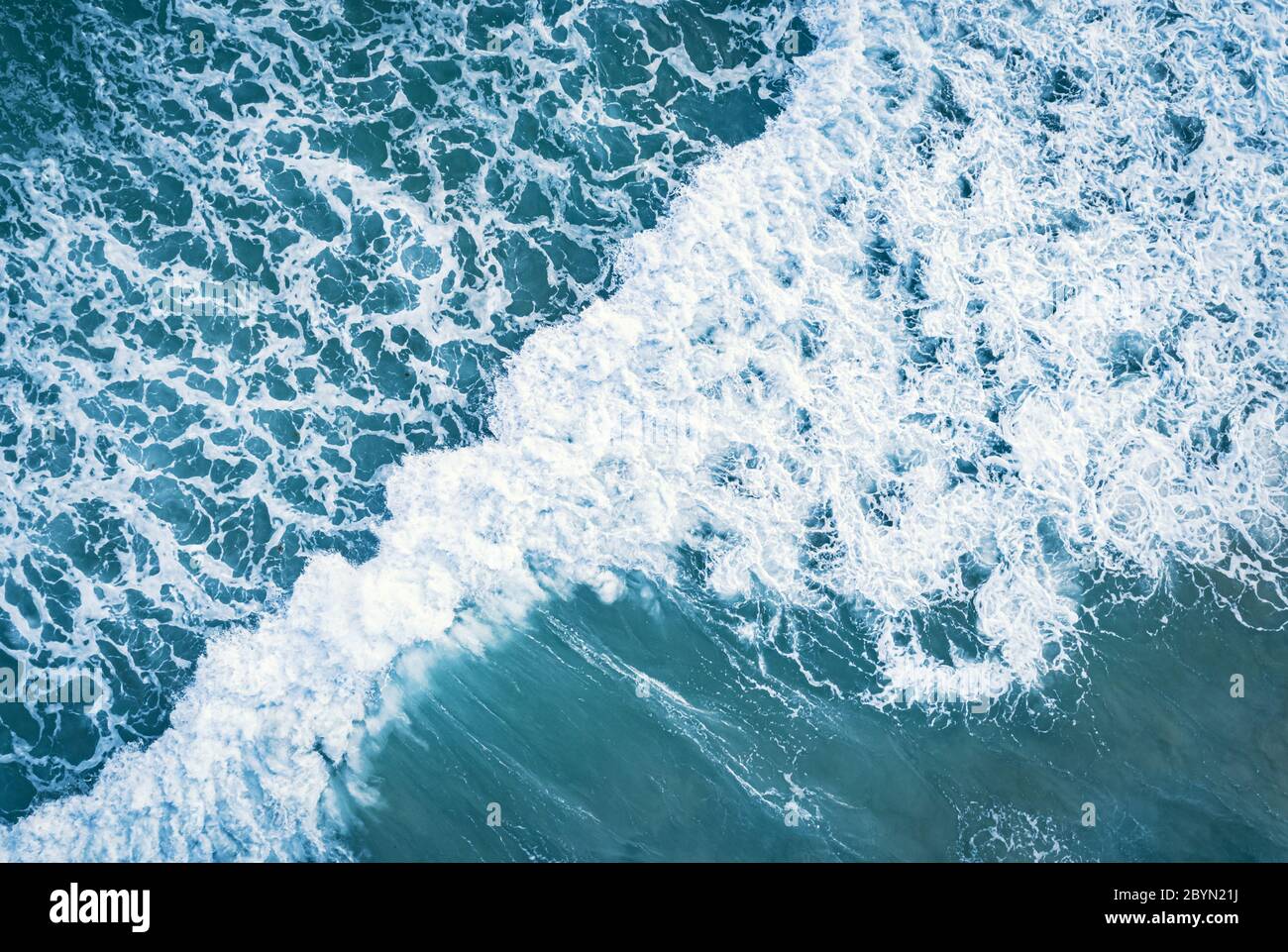 Antenna vista superiore di schiuma bianca sulla superficie del mare blu. Foto Stock