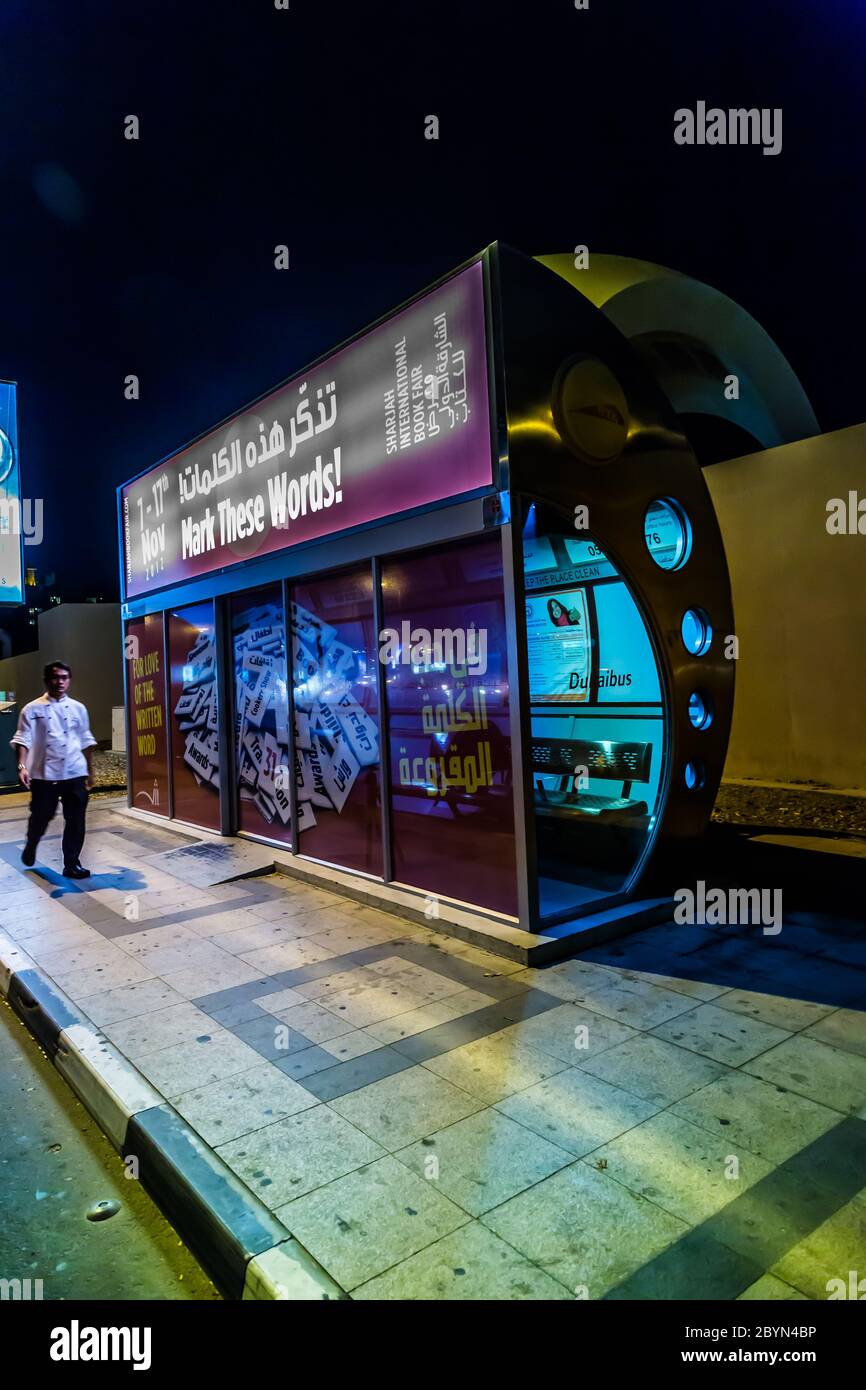 Una fermata dell'autobus con aria condizionata a Dubai con un riflesso turistico nel vetro. Foto Stock