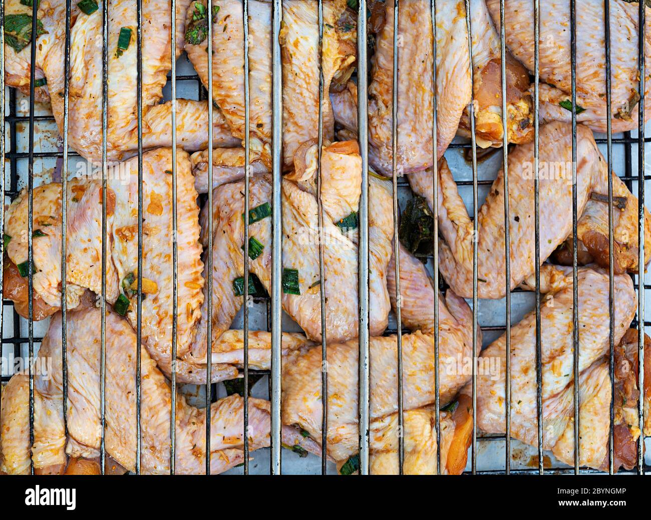 Ali di pollo crude in marinata. Ali di pollo alla griglia Foto Stock