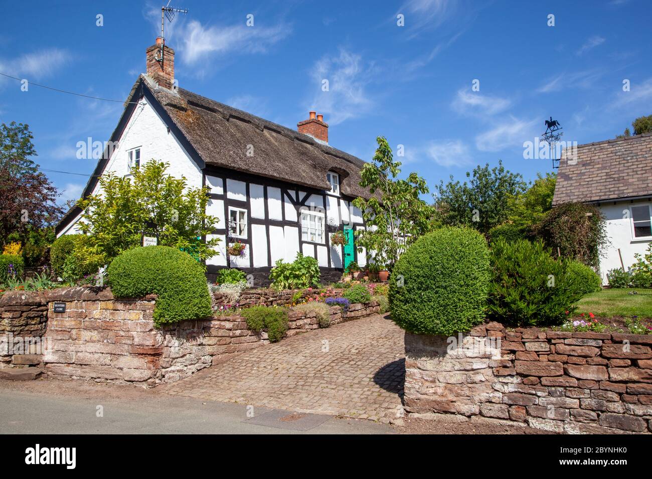 Quintessential idilliaco pittoresco cottage di campagna in legno bianco e nero con tetto in paglia nel villaggio rurale Cheshire di Eaton Foto Stock