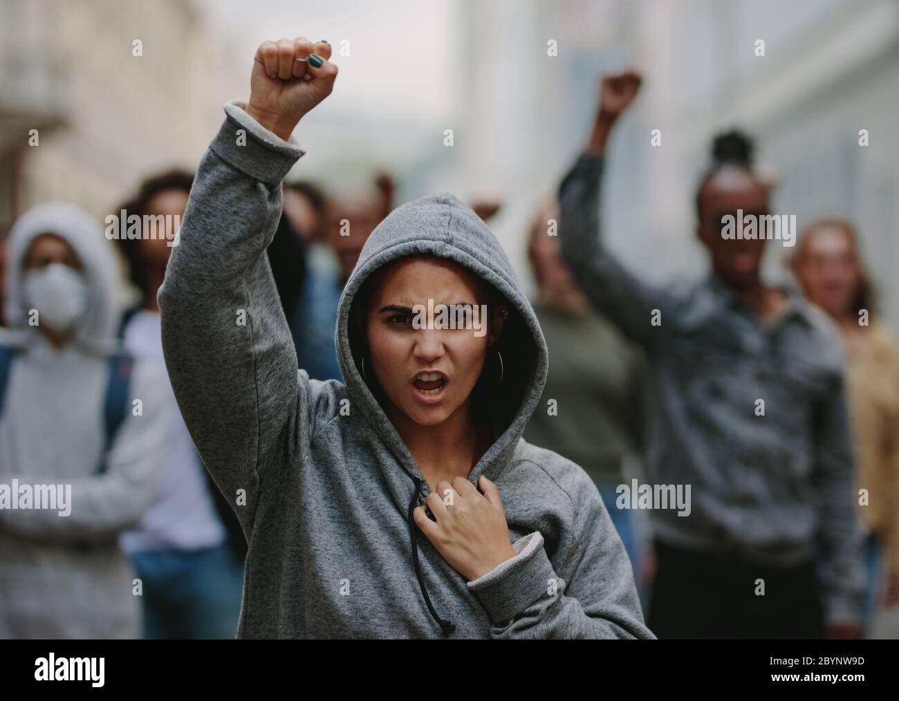 Gruppo di attivisti che danno slogan in una marcia di protesta. Giovani che protestano per la tutela dei diritti civili. Foto Stock