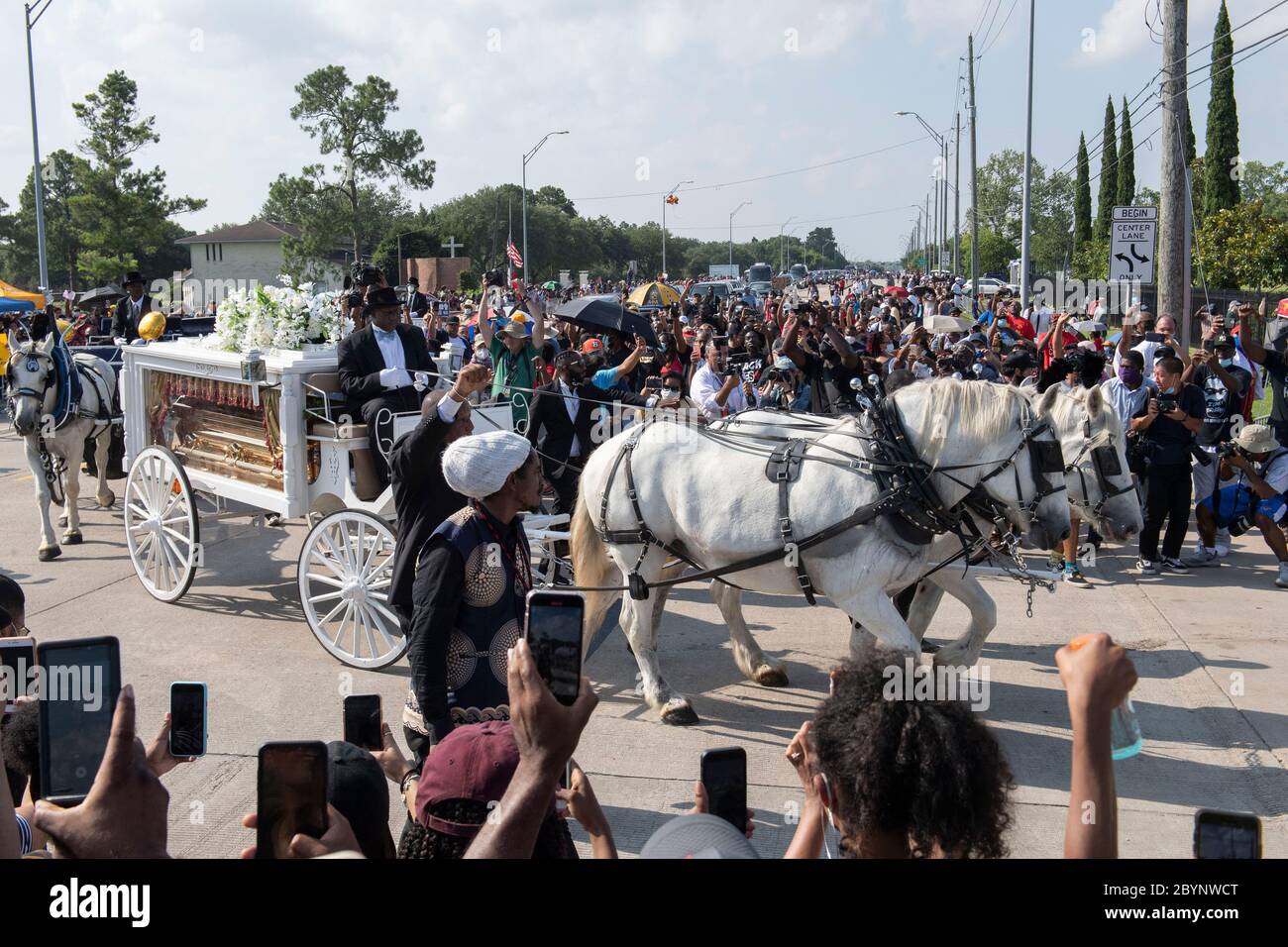 Una carrozza trainata da cavalli contenente il corpo di George Floyd si avvicina al cimitero dei Memorial Gardens di Houston, nella periferia di Houston, dove sarà sepolto accanto alla madre. La morte di Floyd, ucciso a fine maggio da un poliziotto bianco, ha scatenato proteste in tutto il mondo contro il razzismo e la brutalità della polizia. Foto Stock