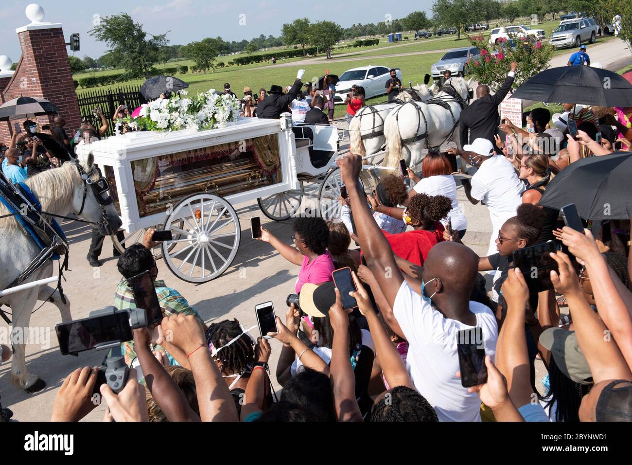 Una carrozza trainata da cavalli contenente il corpo di George Floyd si avvicina al cimitero dei Memorial Gardens di Houston, nella periferia di Houston, dove sarà sepolto accanto alla madre. La morte di Floyd, ucciso a fine maggio da un poliziotto bianco, ha scatenato proteste in tutto il mondo contro il razzismo e la brutalità della polizia. Foto Stock