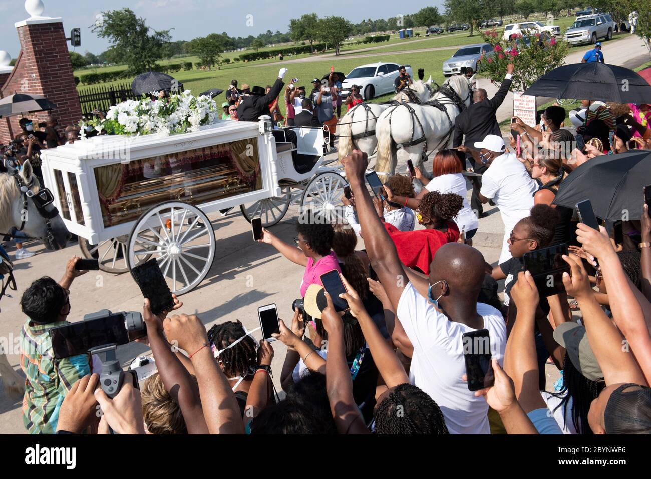 Una carrozza trainata da cavalli contenente il corpo di George Floyd si avvicina al cimitero dei Memorial Gardens di Houston, nella periferia di Houston, dove sarà sepolto accanto alla madre. La morte di Floyd, ucciso a fine maggio da un poliziotto bianco, ha scatenato proteste in tutto il mondo contro il razzismo e la brutalità della polizia. Foto Stock