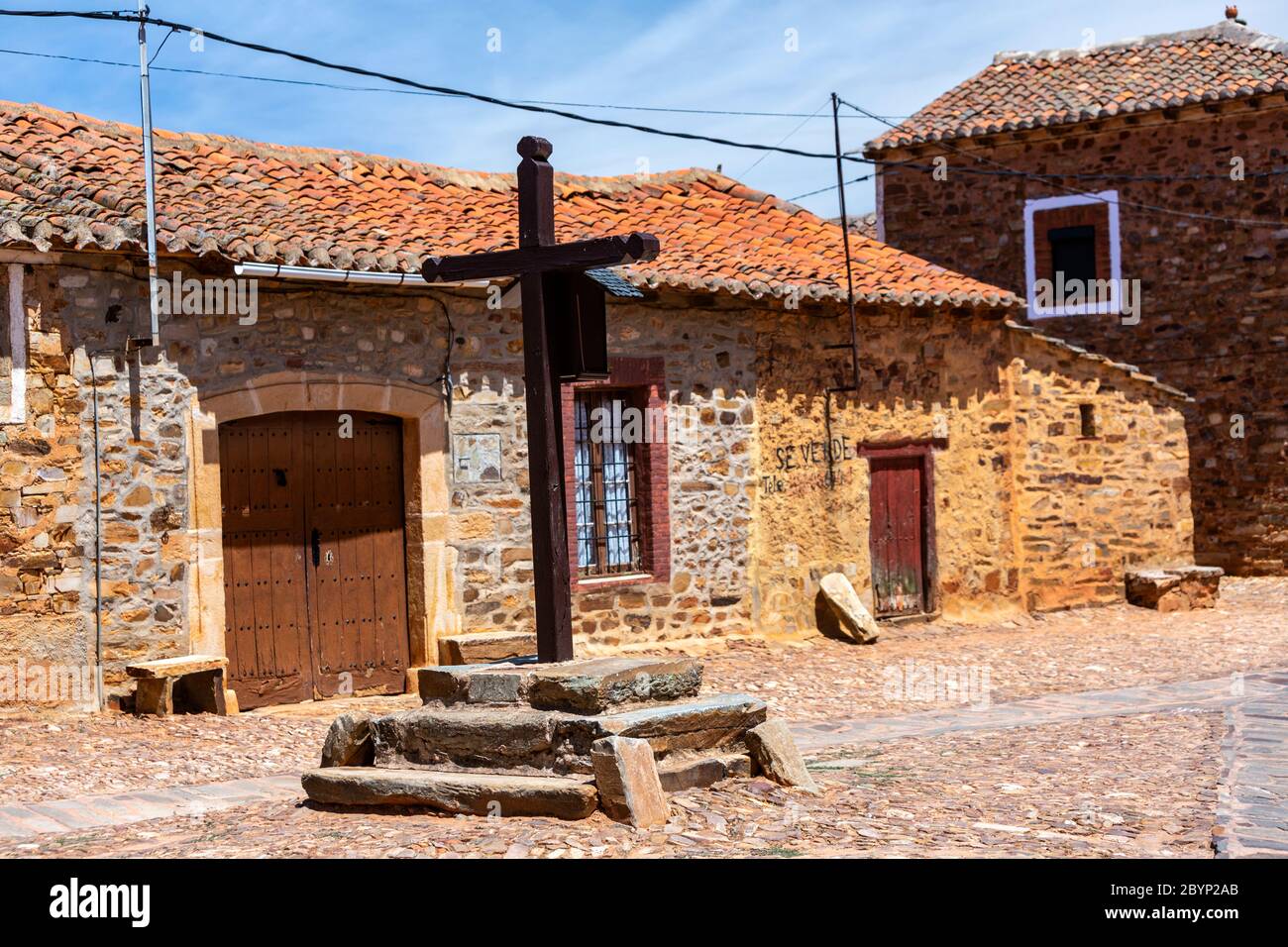Croce di legno in Calle Real con case in pietra a Castrillo de los Polvazares, provincia di Leon, Castiglia e León. , Spagna Foto Stock