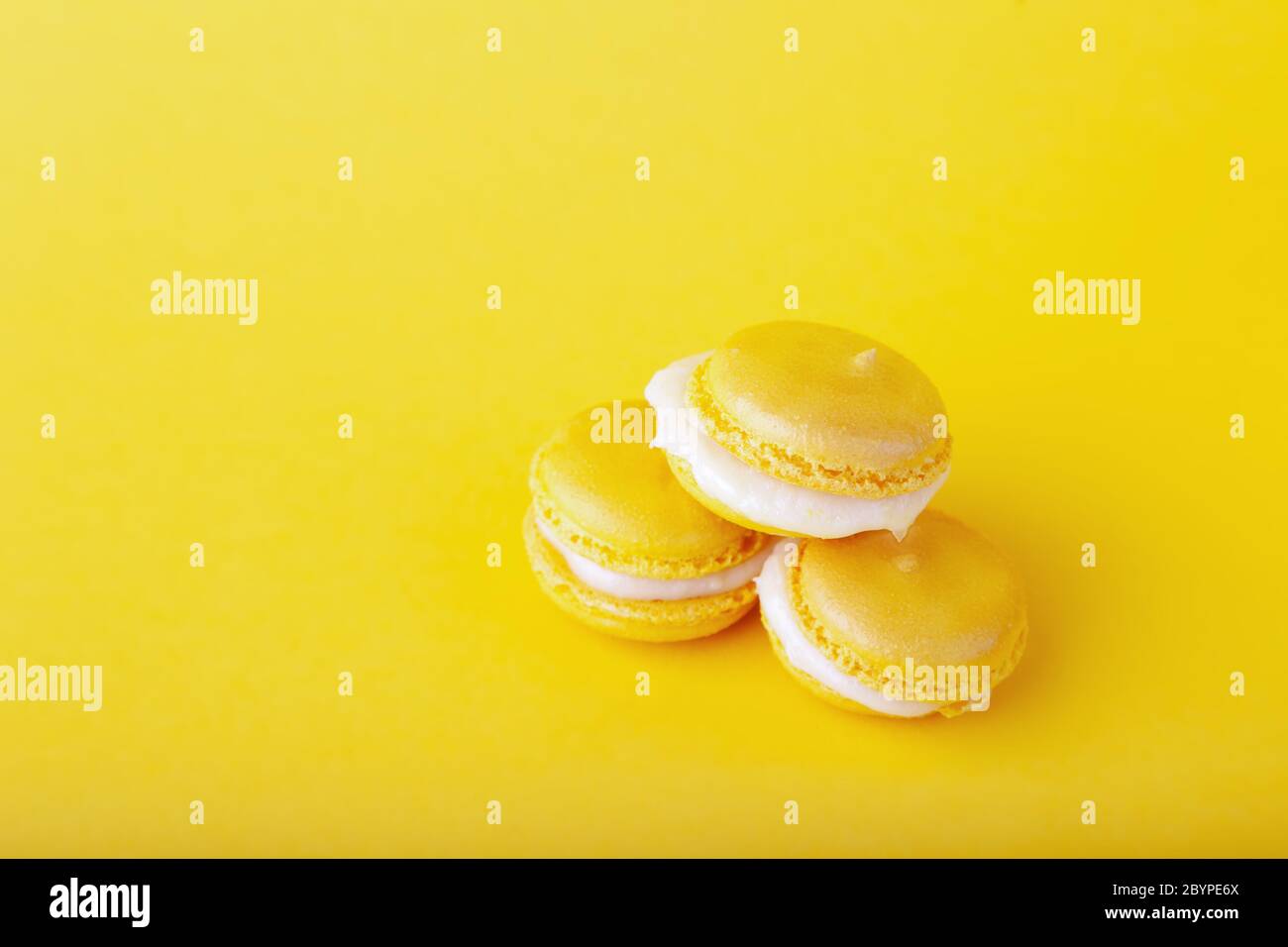 Tre amaretti gialli di limone in pelo su sfondo giallo Foto Stock