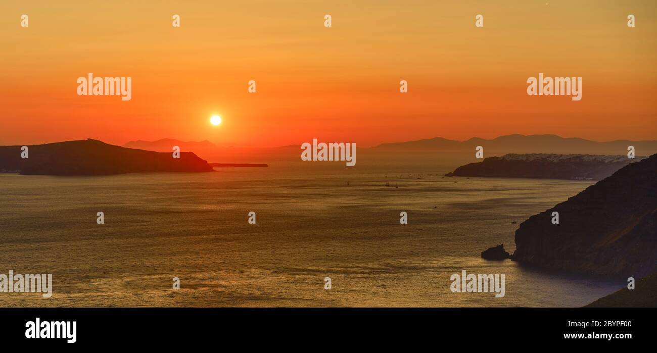 Il tramonto si avvicina sulle isole e la caldera intorno a Santorini e il Mar Egeo in Grecia, come visto da Fira. Foto Stock