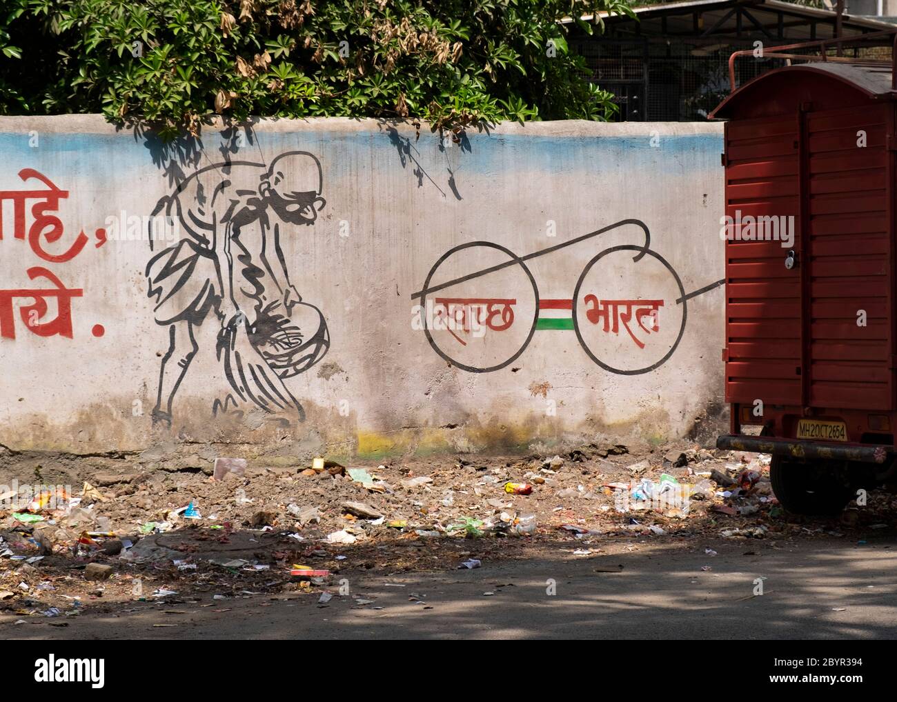Spazzatura di fronte a un muro con uno slogan che promuove un pulito India, Aurangabad, Maharashtra, India. Foto Stock