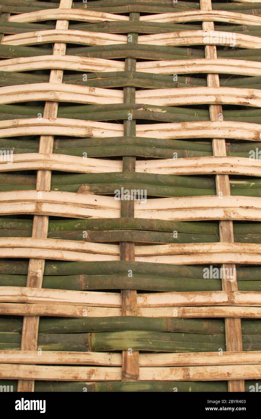 Tessuto di bambù trama sfondo design naturale artigianato verticale. Natura sfondo di verde e giallo artigianato tessitura superficie di bambù tessitura. Foto Stock