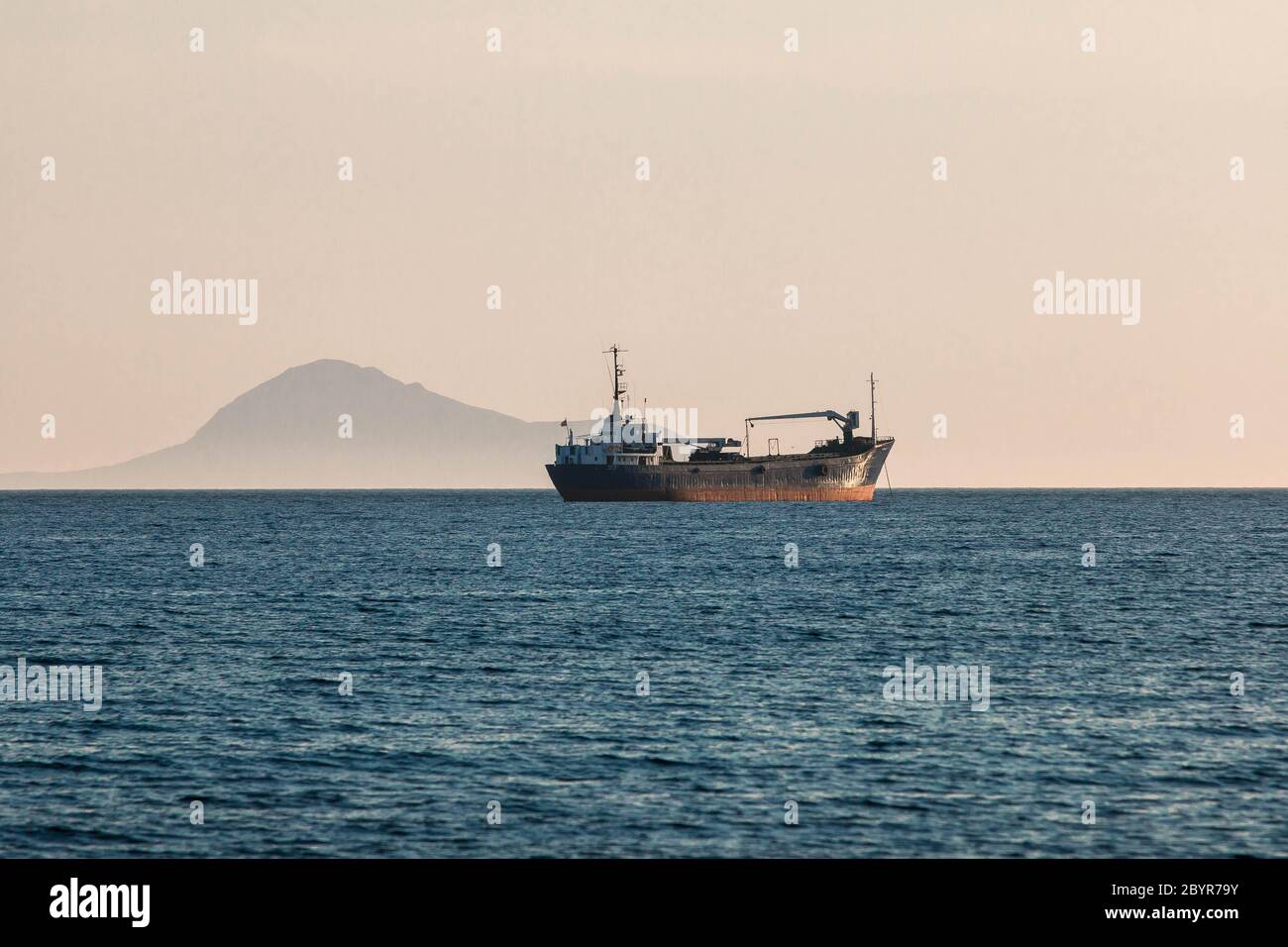 Petroliera vela sul mare blu calmo Mediterraneo con montagna sullo sfondo Foto Stock