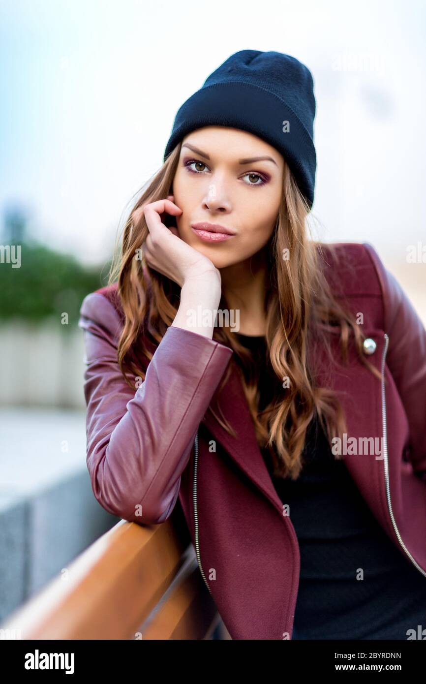 Giovane donna seduta su una panchina. Foto Stock