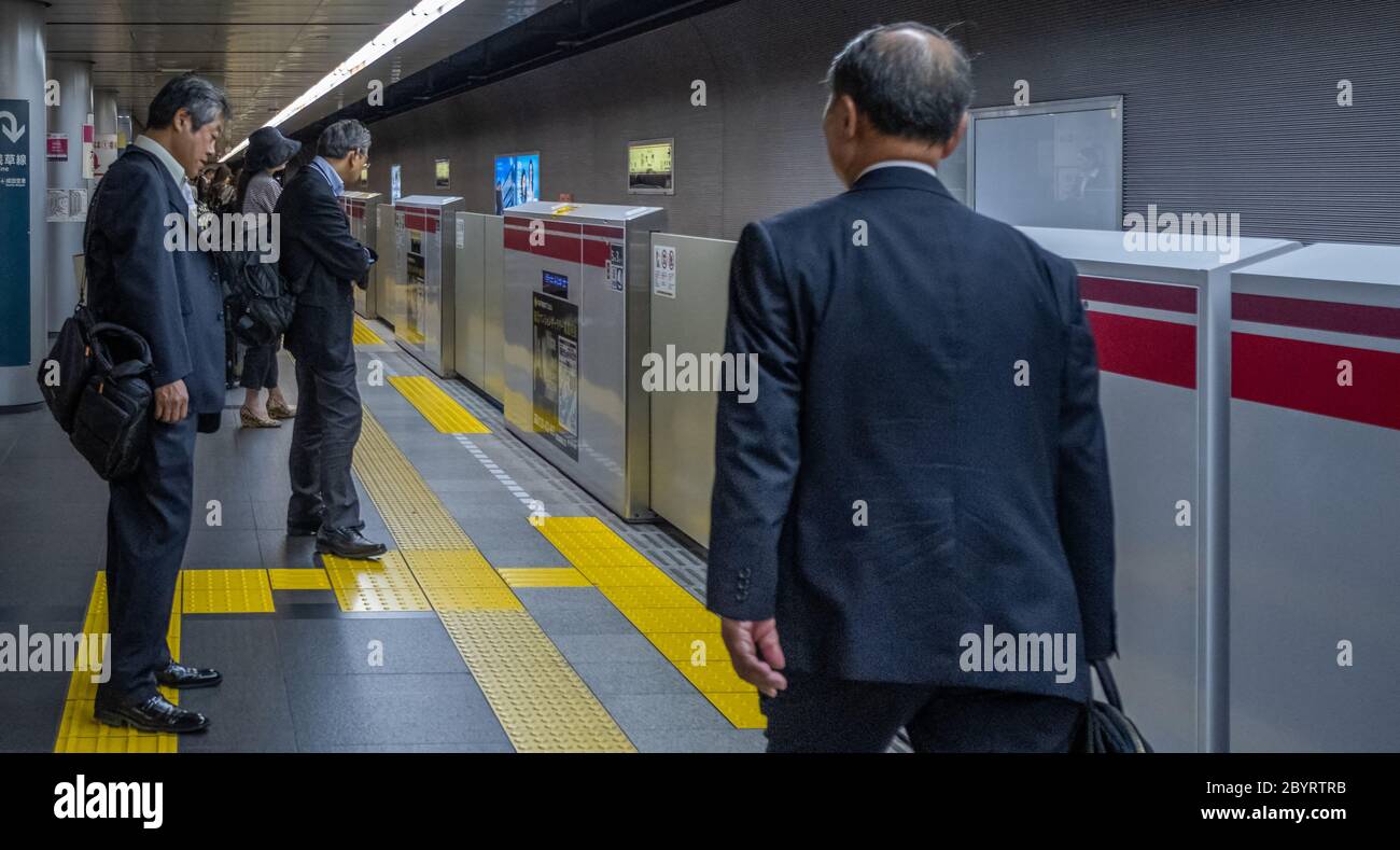 Pendolari alla piattaforma della stazione della metropolitana di Tokyo, Tokyo, Giappone Foto Stock