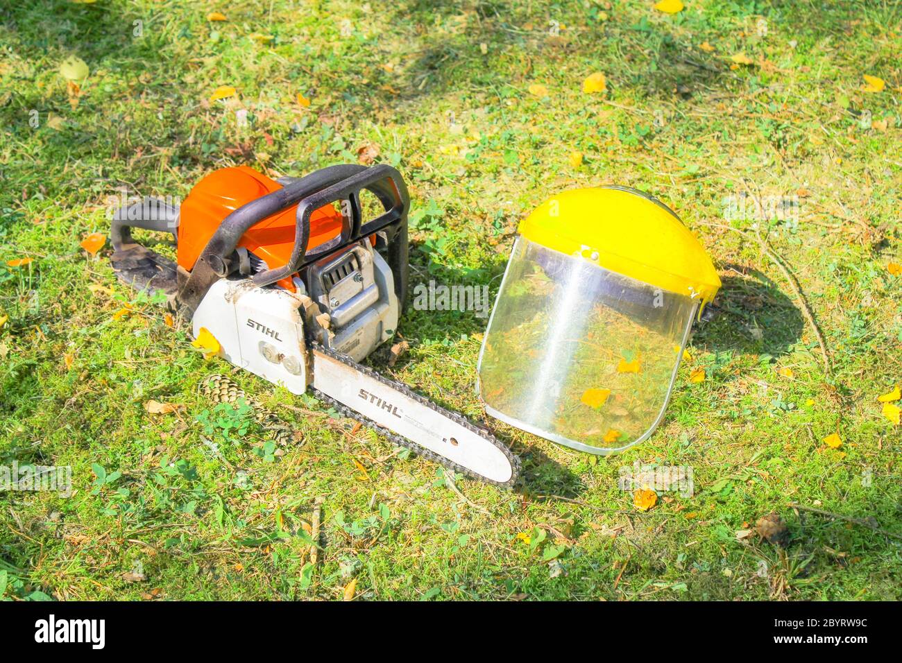 Sega a catena Stihl e casco di protezione su erba Foto Stock
