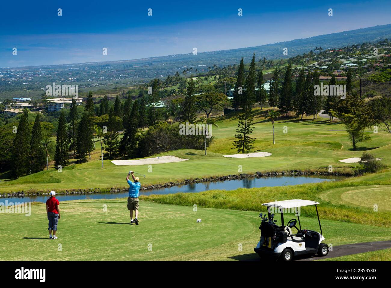 Marito e moglie di golf coppia (modello rilasciato) tee off sul Kona Mountain Golf Course, (proprietà rilasciata) a Kailua Kona, Hawaii. Foto Stock