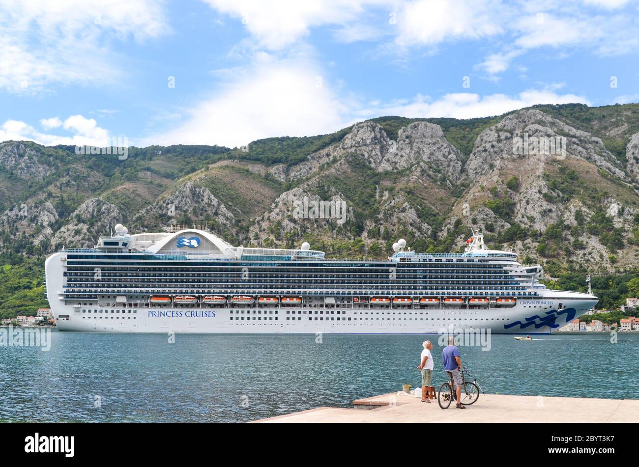 La gente del posto guarda una grande nave da crociera nella baia di Kotor, Montenegro Foto Stock