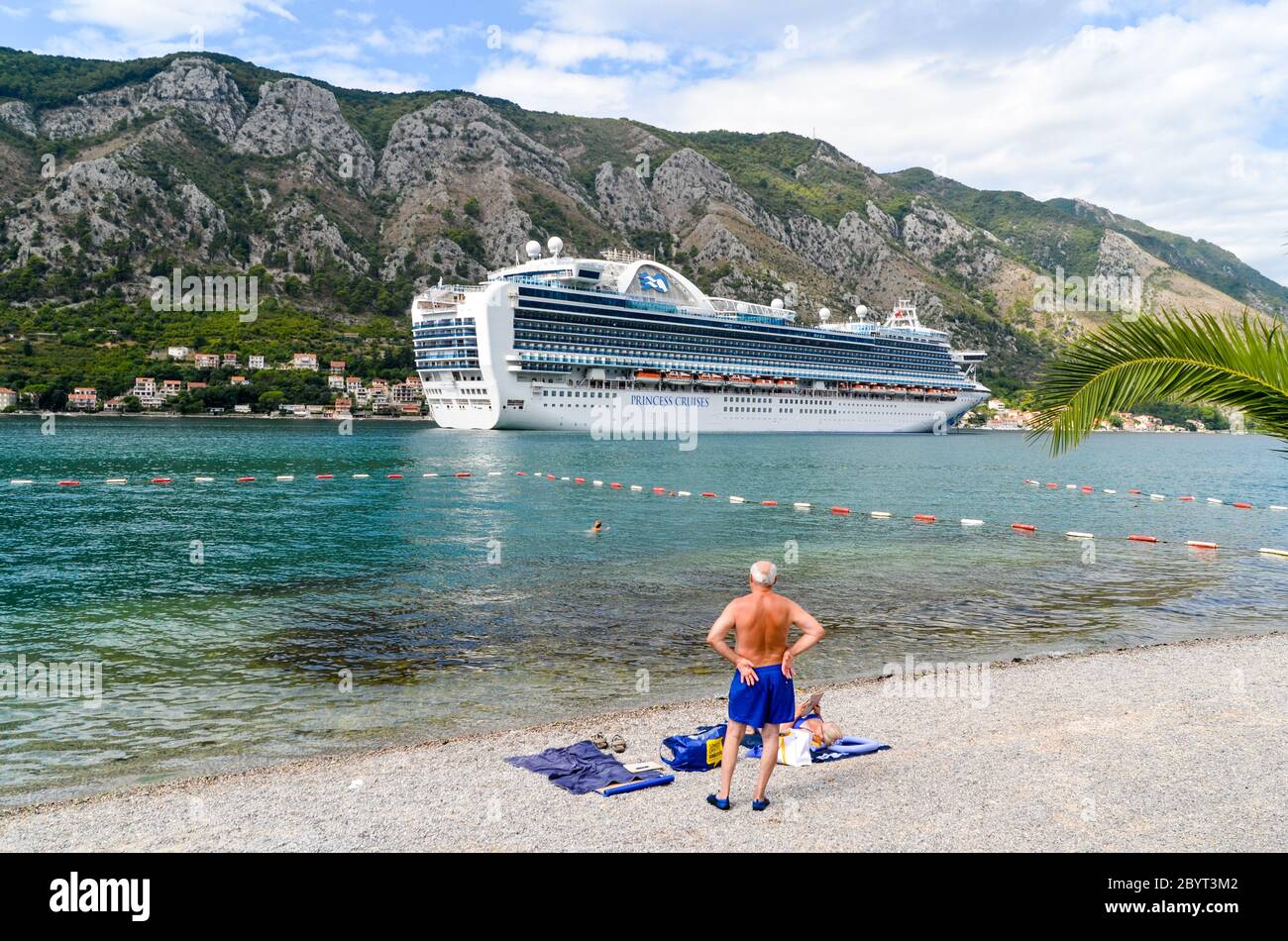 La gente del posto guarda una grande nave da crociera nella baia di Kotor, Montenegro Foto Stock