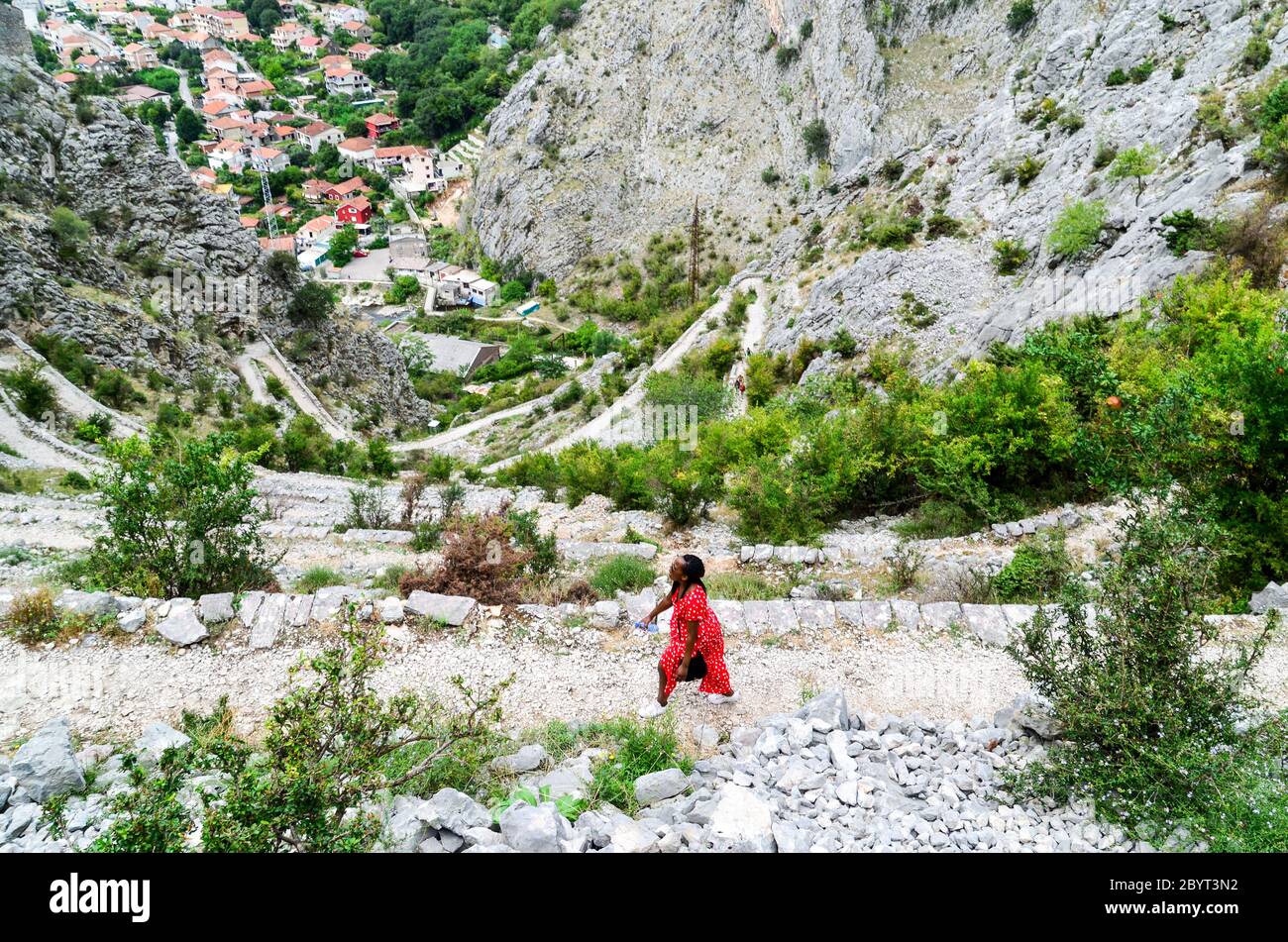 Donna escursioni sulla cima della fortezza di Cattaro, Baia di Cattaro, Montenegro Foto Stock
