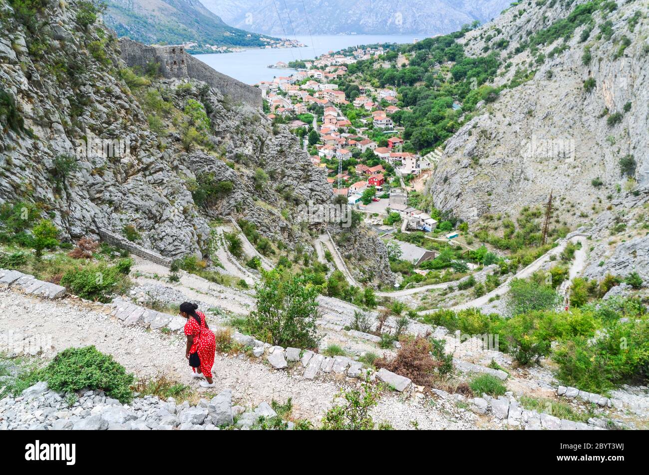 Donna escursioni sulla cima della fortezza di Cattaro, Baia di Cattaro, Montenegro Foto Stock