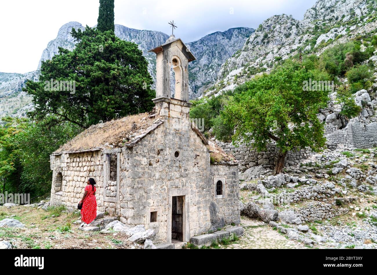 Donna escursioni sulla cima della fortezza di Cattaro, Baia di Cattaro, Montenegro Foto Stock