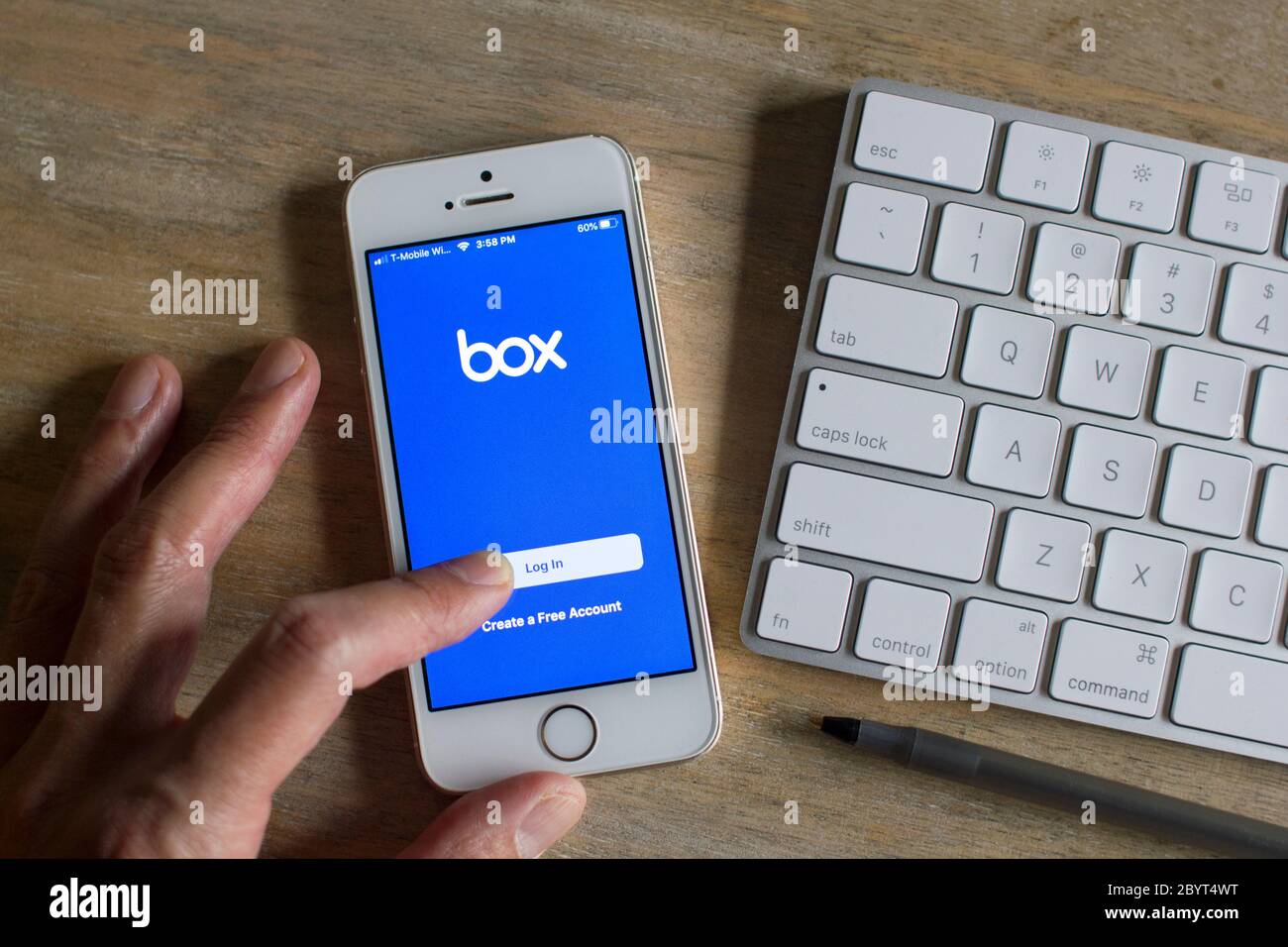 Un uomo d'affari che utilizza l'app mobile Box sul suo telefono. La società tecnologica Box, Inc., con sede in California, è un servizio di condivisione file e gestione dei contenuti cloud. Foto Stock