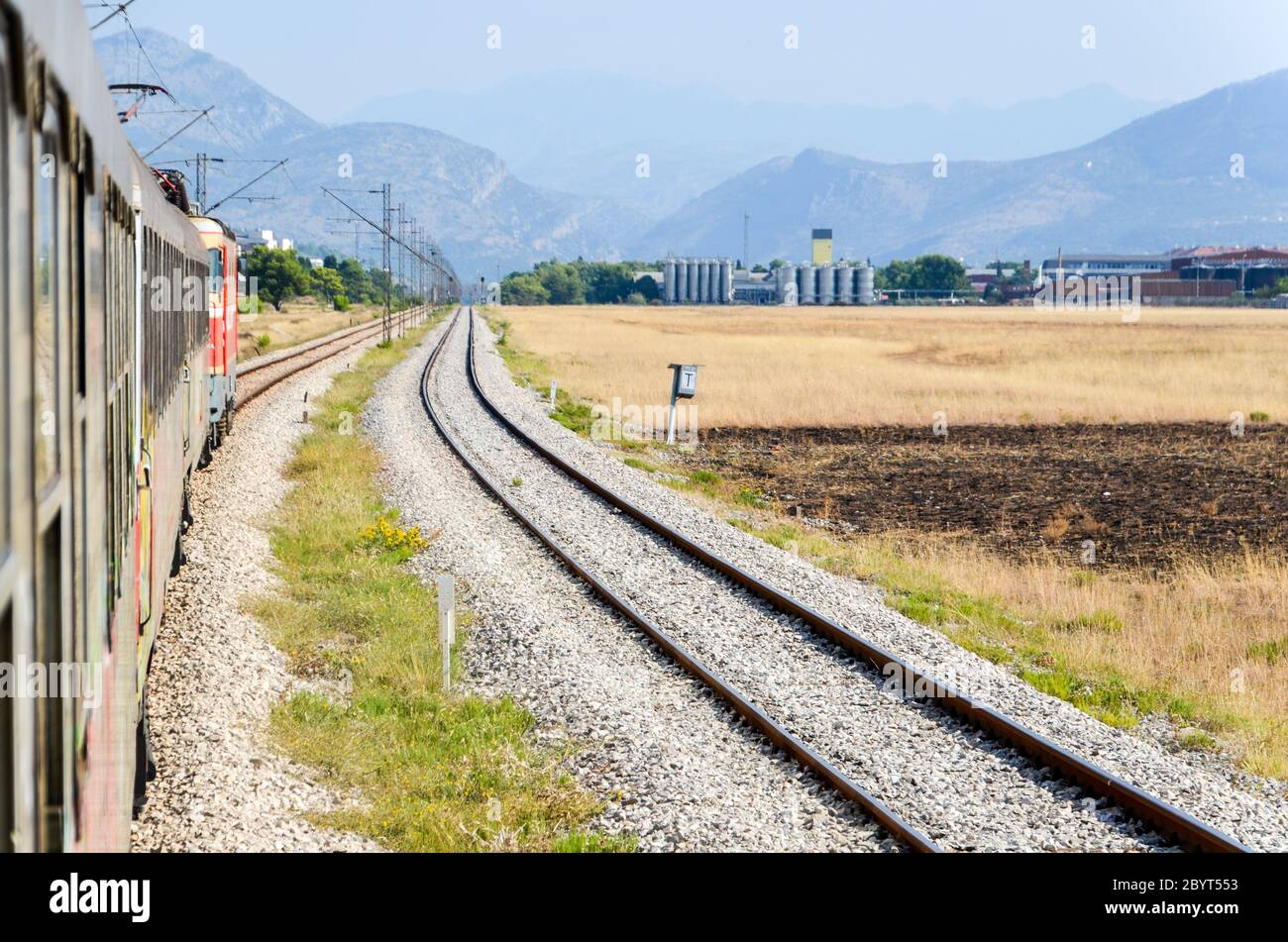 Vista di Podgorica (capitale montenegrina) dal treno lungo la ferrovia Bar-Belgrado nei Balcani (Montenegro, Serbia) Foto Stock
