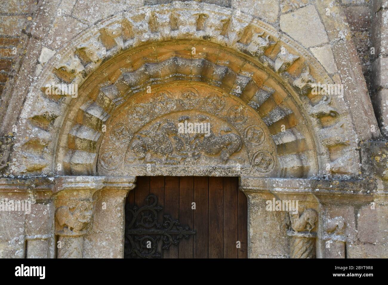 La chiesa di tutti i Santi, Lullington nr. Frome , Somerset. La porta Nord Normanna con un timpano, tre ordini di decorazione e (un po 'di tempo) Foto Stock