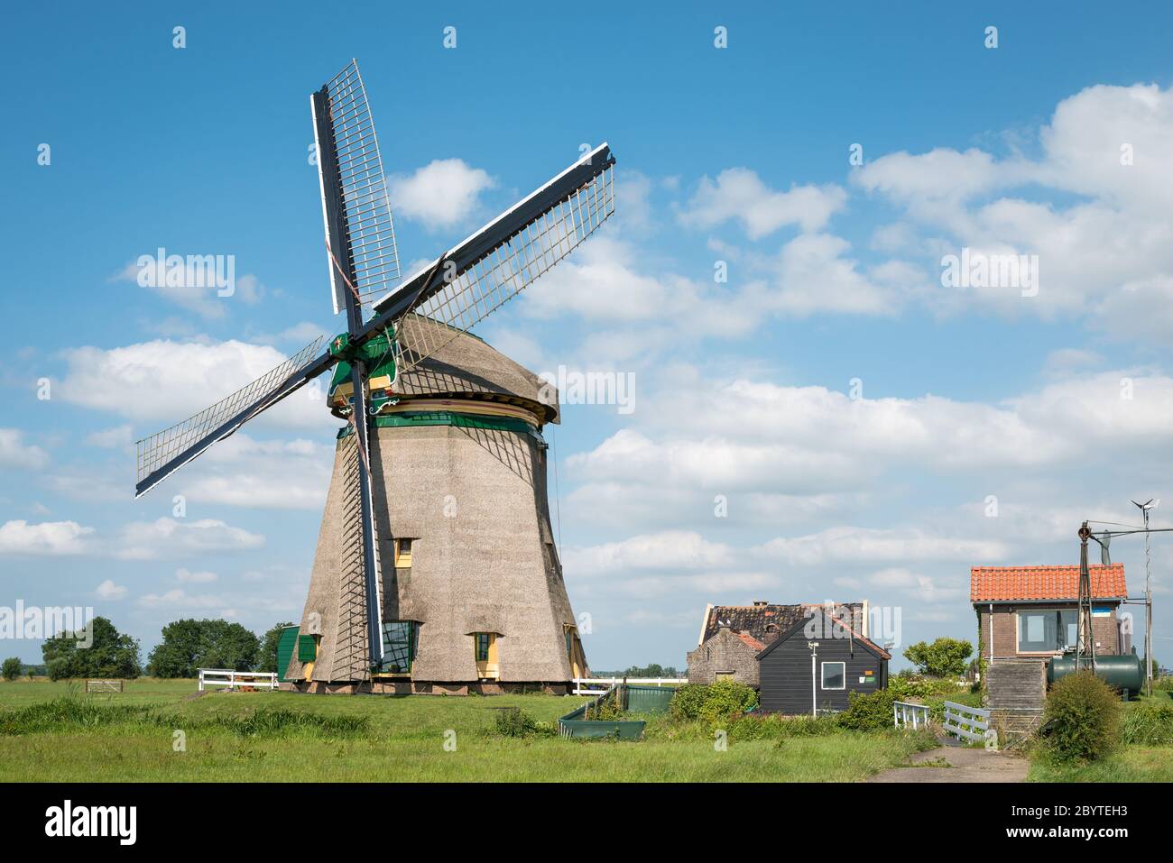 Mulino a vento tradizionale olandese con casa di pompaggio. Mulino vicino al villaggio di Koudekerk aan den Rijn è chiamato 'Honsdijke Molen'. Foto Stock