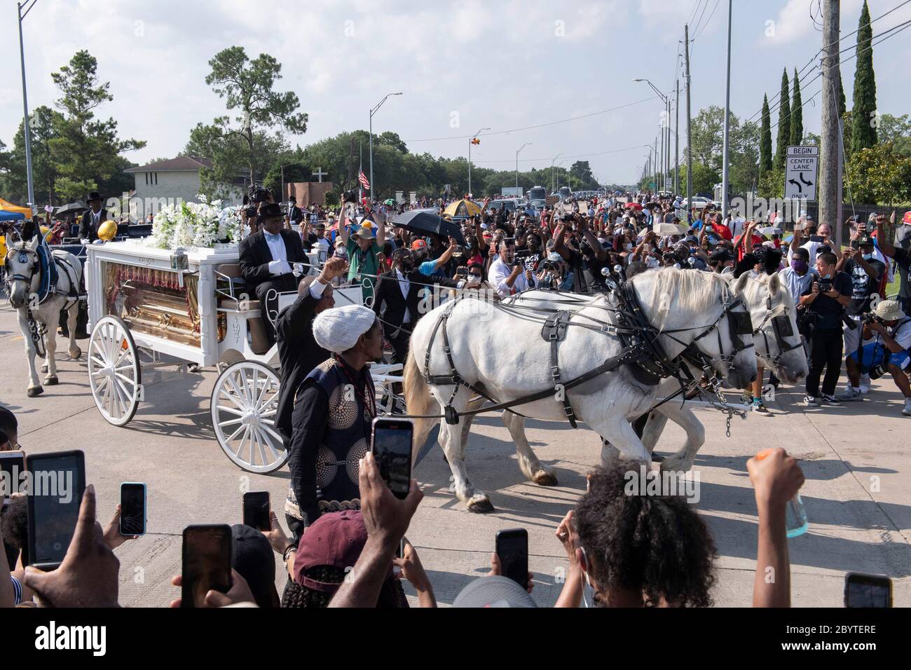 Una carrozza trainata da cavalli contenente il corpo di George Floyd si avvicina al cimitero dei Memorial Gardens di Houston, nella periferia di Houston, dove sarà sepolto accanto alla madre. La morte di Floyd, ucciso a fine maggio da un poliziotto bianco, ha scatenato proteste in tutto il mondo contro il razzismo e la brutalità della polizia. Foto Stock