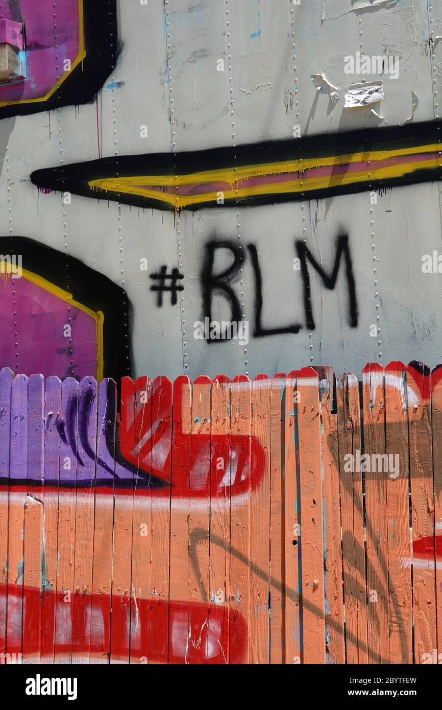 Il hashtag BLM per la materia nera di vite è verniciato a spruzzo su una parete coperta di graffiti. Foto Stock