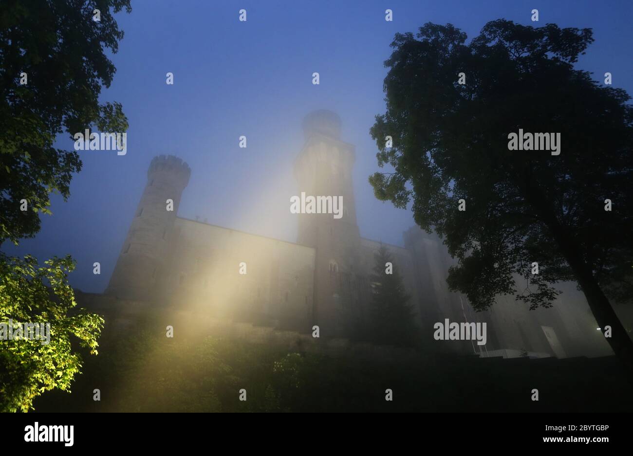 Schwangau, Germania. 10 Giugno 2020. Alla luce di 47 faretti a LED, il Castello di Neuschwanstein è in piedi sotto la pioggia. La conversione al nuovo sistema di illuminazione costa 300,000 euro. I faretti non solo dovrebbero fornire una luce migliore, ma anche essere più insetto-friendly e risparmiare energia elettrica. Credit: Karl-Josef Hildenbrand/dpa/Alamy Live News Foto Stock