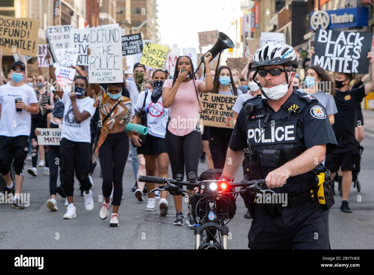 Un poliziotto si avvicina a una folla di manifestanti della materia Black Lives mentre condannano le forze dell'ordine a Toronto, Ontario. Foto Stock
