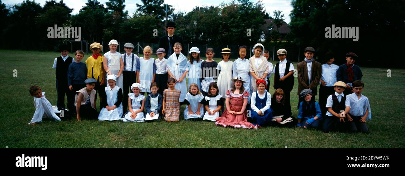 Classe in Vittoriano vestito scuola primaria bambini e insegnante Foto Stock