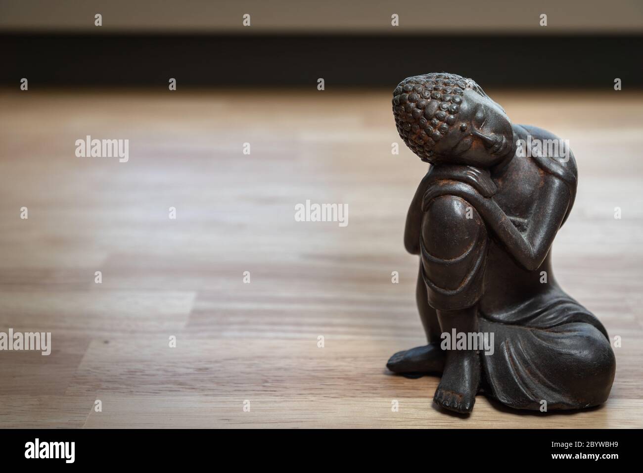 Scultura Buddha sulla scrivania - statua in miniatura buddha sulla scrivania - immagine concettuale per mediazione, consapevolezza, relax, filosofia Foto Stock